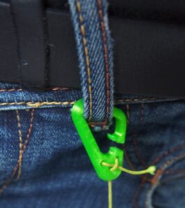 Lien à connecter à un passant de ceinture de pantalon (goupille bloquante qui permet d’ajuster la longueur).