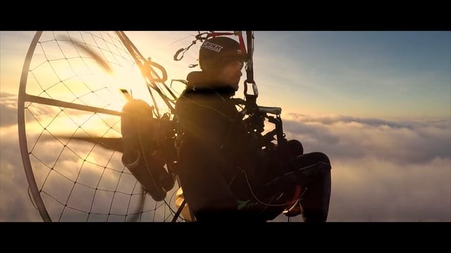 Vol paramoteur au coucher du soleil et au dessus des nuages